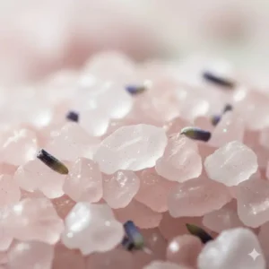 A close-up shot showing the coarse and shimmering texture of pink and white soothing bath crystals.